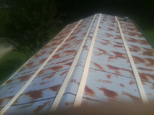Rusted metal roof panels with new wood purlins before replacement — Storm Damage Roof Repair in Conesus by Roofing Brothers